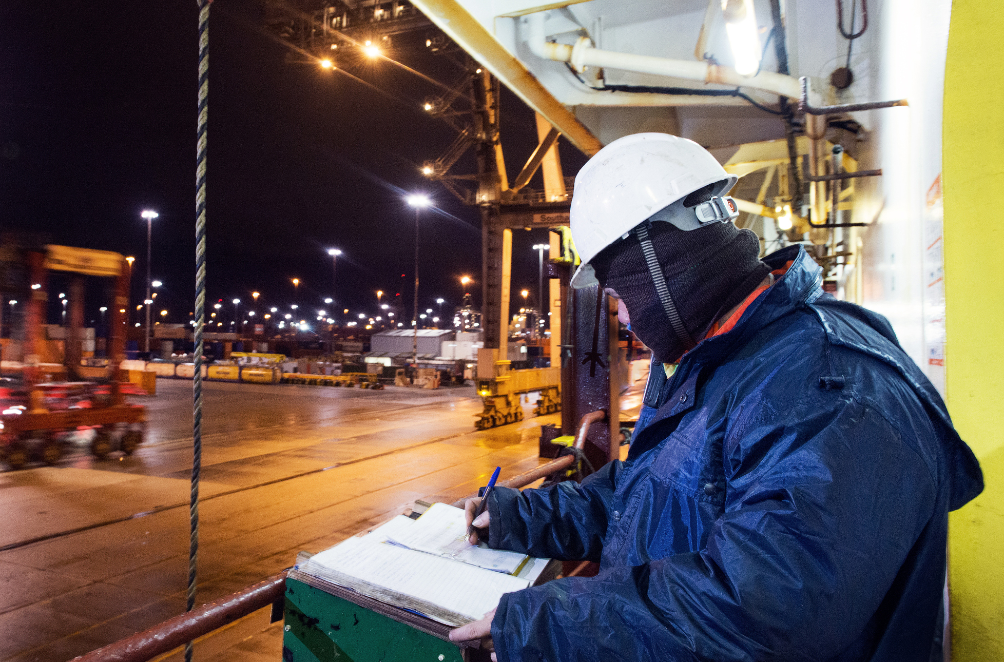 Seafaring workman completing paperwork on site at night